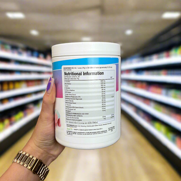 Close-up of (Per4m Pre Workout Stim 570g 30 Servings) held up inside My Supplement Shop, clearly showing Nutritional Values on the packaging in a Sports Nutrition setting.