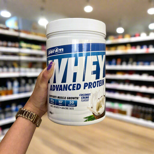 Close-up of (PER4M Whey Protein Powder 900g) held up inside My Supplement Shop, clearly showing the front label in a Sports Nutrition setting.